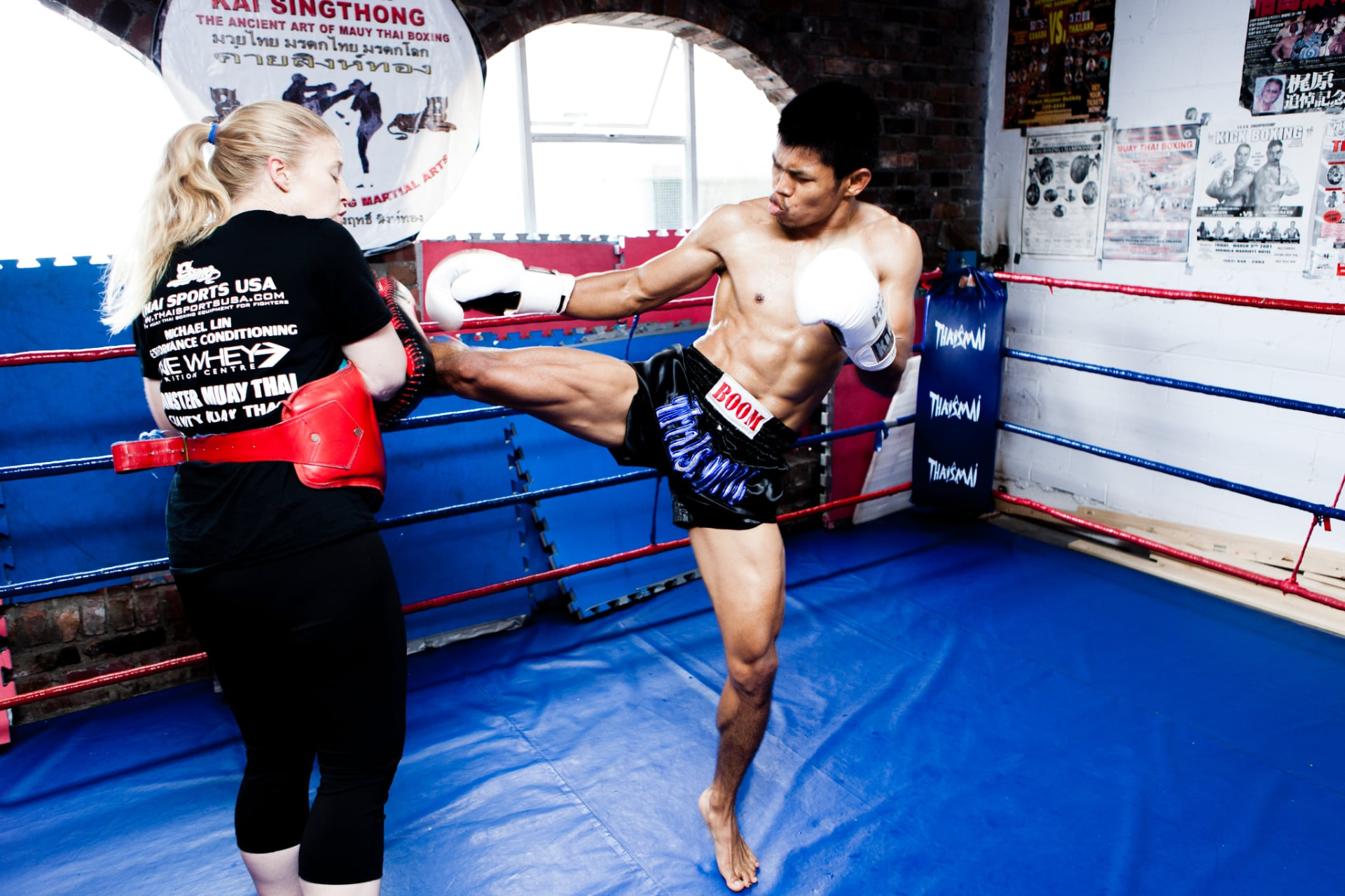 Frances and Boom training together in a Muay Thai ring.